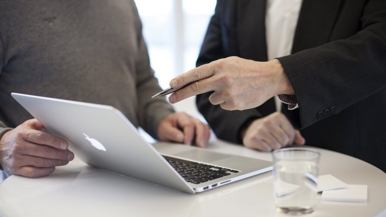 Profissionais analisando informações digitais durante atendimento consultivo